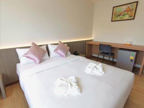 a white bed with pink and white bows on it at Orchid Residence Suratthani in Suratthani