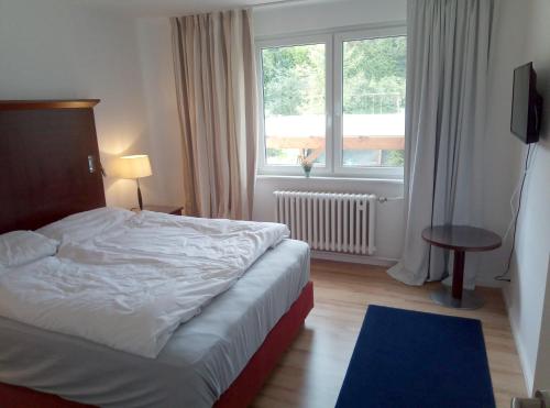 1 dormitorio con cama y ventana grande en Haus Löwenzahn en Hüttenrode