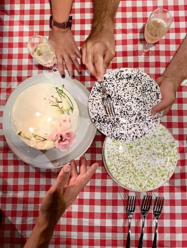 a group of people reaching for plates on a table at Galeta Masseria in Nardò