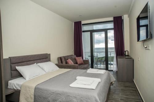 1 dormitorio con 1 cama con 2 toallas en Hotel Scala en Shekhvetili