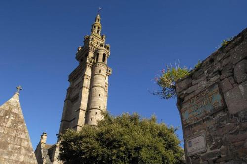 a tall clock tower with a blue sky in the background at Hotel D'Angleterre in Roscoff