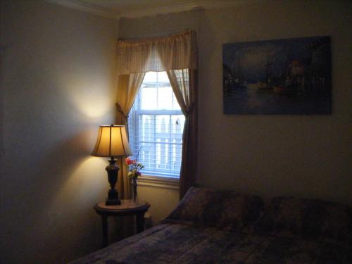 a bedroom with a bed and a window with a lamp at Moffett House Inn in Provincetown