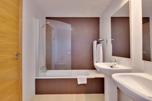 Baño blanco con bañera y lavamanos en Ona Mar Menor - The Residences, en Torre-Pacheco