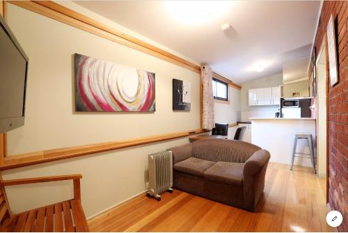 a living room with a couch and a kitchen at NORD - North Hobart Apartments in Hobart