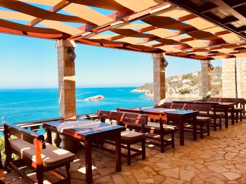 a group of tables and chairs on a patio with the ocean at Guest house Naser in Ulcinj
