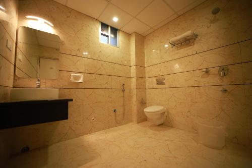 a bathroom with a toilet and a sink and a mirror at Click Hotel Capital House in Patna