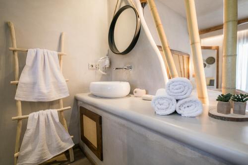 a bathroom with a sink, towels, and a towel rack at Sunrise Village Hotel Apartments in Skopelos Town