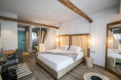 a hotel room with a bed and a dresser at Sunrise Village Hotel Apartments in Skopelos Town