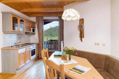 a kitchen with a wooden table and a dining room at Alpenhotel Wanderniki in Liesing