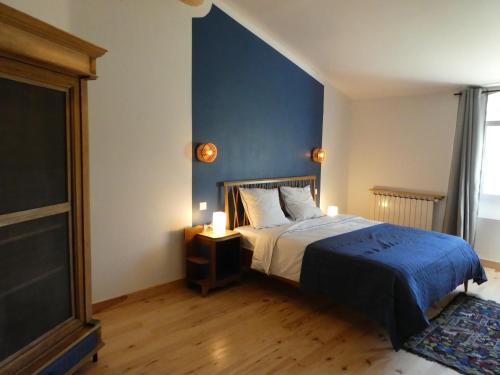 sypialnia z łóżkiem i niebieską ścianą w obiekcie L'auguste maison d'hôtes w mieście Valensole
