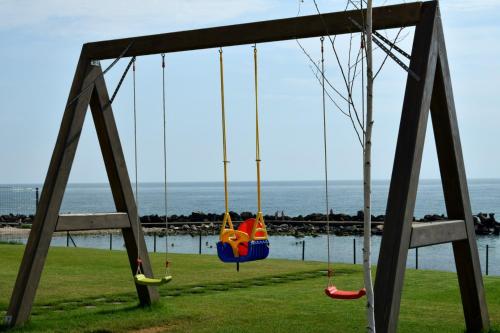 a swing in a park with the ocean in the background at Hotel Cometa in Jupiter