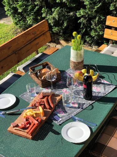 a picnic table with a plate of food and wine at Landhaus Daum in Schwendau