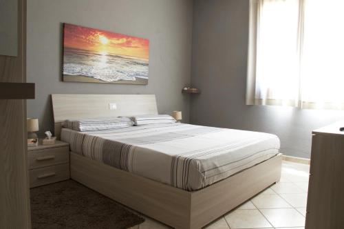 um quarto com uma cama e um quadro na parede em Condominio Le Palme em Santa Teresa Gallura