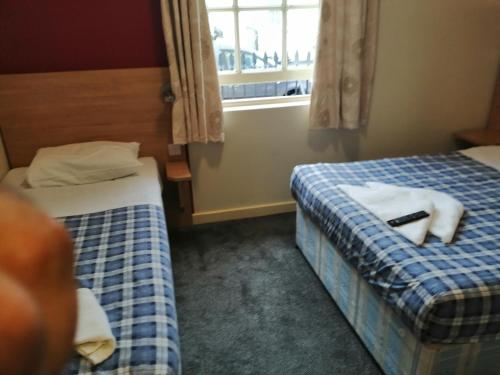 a hotel room with two beds and a window at Colliers Hotel in London