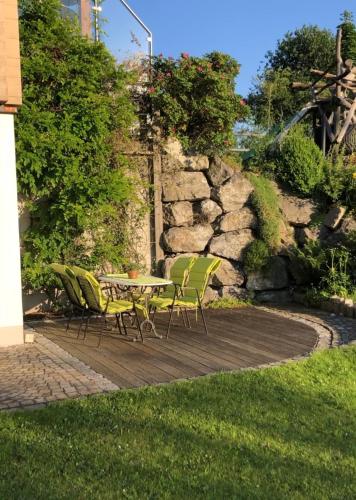 una mesa y sillas en una terraza de madera en Ostallgäu, en Ruderatshofen