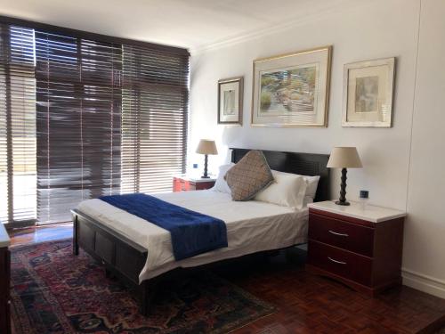 a bedroom with a bed and a chair and a window at Sandton Luxury Living at 102 Kambula in Johannesburg