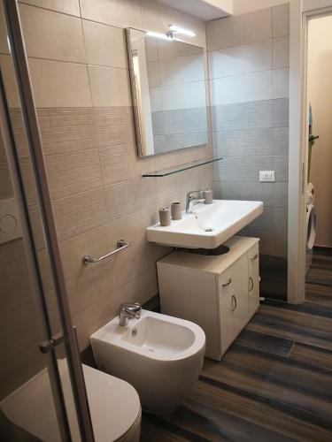 a bathroom with a sink and a toilet and a mirror at Appartamenti Acquazzurra in Portoferraio