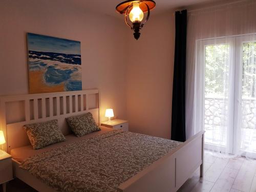 a bedroom with a bed and a large window at Apartmani Elena in Malinska