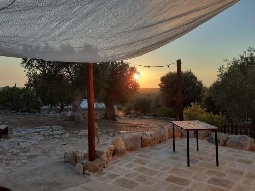 a table under a tent with the sunset in the background at B & B Monte Adamo in Conversano