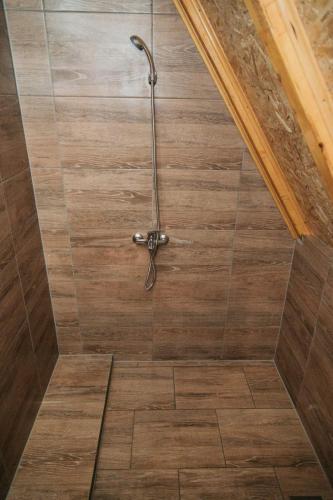 a shower in a bathroom with a wooden floor at Etno Village Dolina Sreće in Vitez