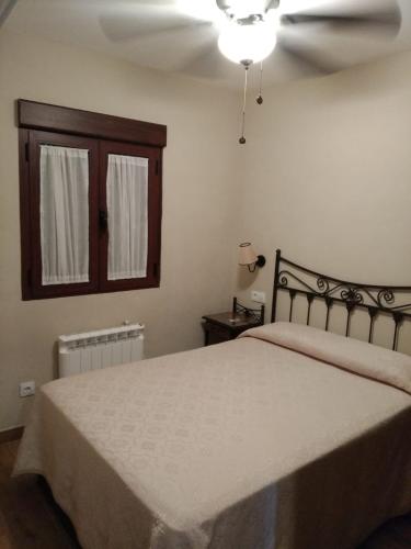 a bedroom with a large bed and a window at EL REFUGIO DE POPEA in Santa María de Trassierra