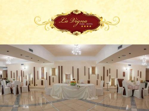 a banquet hall with white tables and white chairs at La Vigna Hotel in Bonea