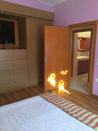 a bedroom with a bed and a closet and a mirror at Cosy Country Villa in Pappayiannádhes