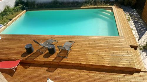 - une piscine avec 2 chaises et une table dans l'établissement Chambre d'hôtes du Charme Provençal, à Sénas