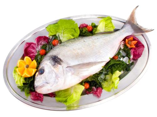 a fish on a plate with lettuce and vegetables at La Vigna Hotel in Bonea