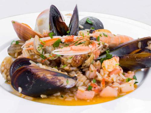 a white plate of food with seafood and rice at La Vigna Hotel in Bonea