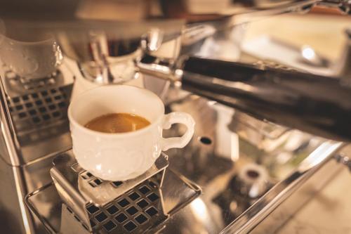 a cup of coffee sitting on top of a stove at Hotel Posta in Cecina