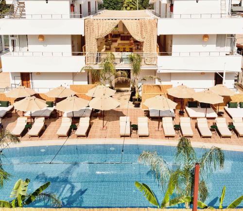 un hotel con piscina, sillas y sombrillas en ESQUIRE HOTELS and LOUNGES en Kemer