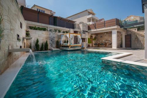 una piscina con una fuente en una casa en Villa Arbanessa with Heated Pool, en Trogir