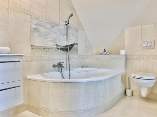 a bathroom with a tub and a toilet at Strázsa Vendégház in Szekszárd