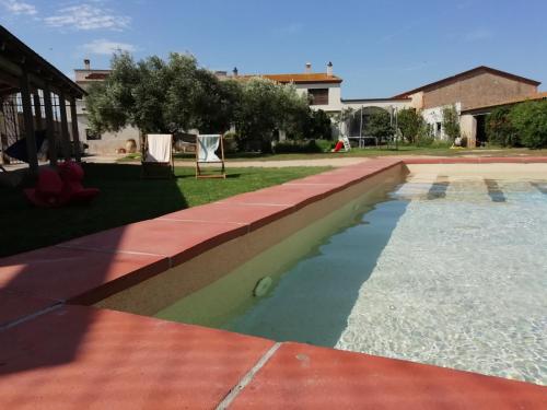 a swimming pool in a yard next to a house at Agroturisme MAS CAN FONT in Ventalló