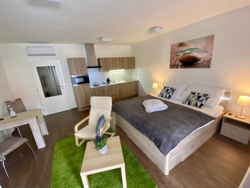 een slaapkamer met een groot bed en een keuken bij Apartmány Duo Třeboň in Třeboň