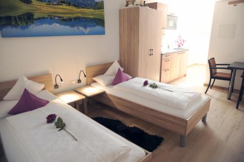 a bed room with two beds and a desk at Pension Lerchenfeld in Schongau