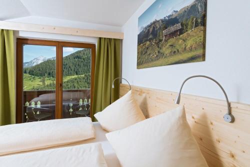 a bedroom with a bed with a view of a mountain at Alpenhotel Wanderniki in Liesing