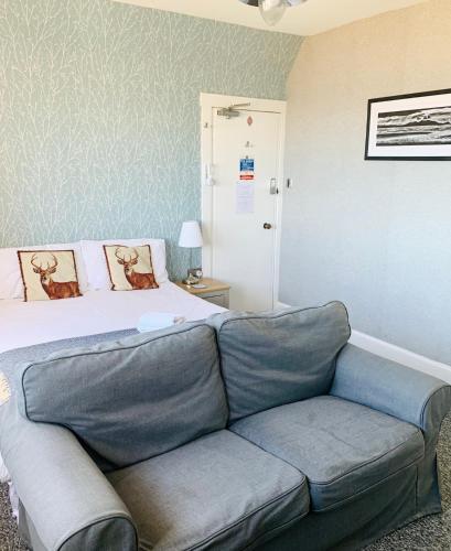 a living room with a couch and a bed at Burlington Guest House in Whiting Bay