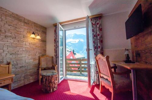 a room with a window with a view of a mountain at Hotel Blumental in Mürren