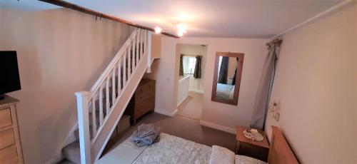 um quarto com uma escada com uma cama em 16th Century 1 Bedroom Cottage (adjacent 10th Century Richmond Castle) em Richmond