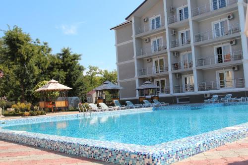 a large swimming pool in front of a building at Отель Анна Мария in Kurortne