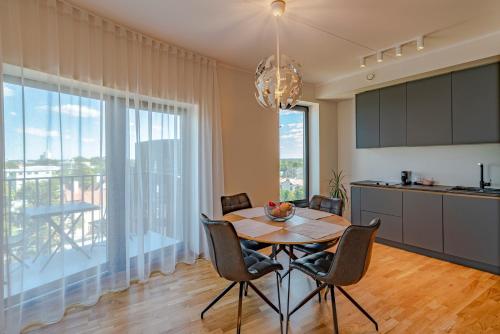 cocina y comedor con mesa y sillas en Artisa Riia Str 22A Luxury apartment en Tartu