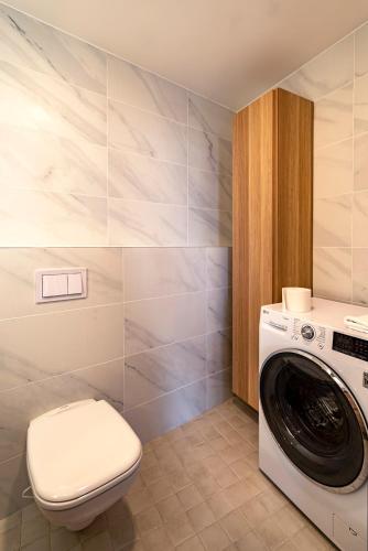 a bathroom with a washing machine and a toilet at Artisa Riia Str 22A Luxury apartment in Tartu