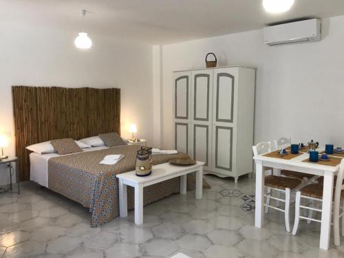 una camera con letto e tavolo e un angolo cottura. di Le Dimore della Villa dei Sogni a Vulcano