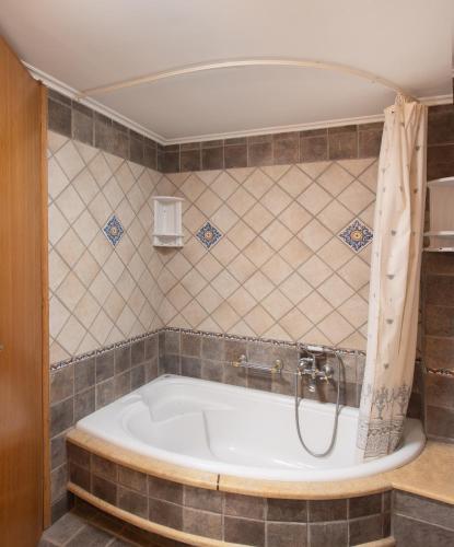 a bath tub with a shower in a bathroom at VILLA AVLOS in Monemvasia
