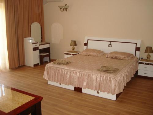 a bedroom with a large bed and two night stands at Отель Анна Мария in Kurortne