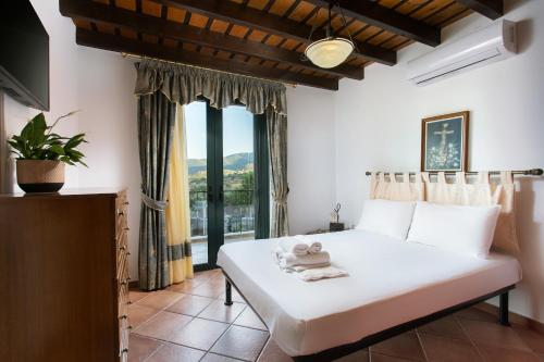 a bedroom with a bed and a large window at VILLA AVLOS in Monemvasia