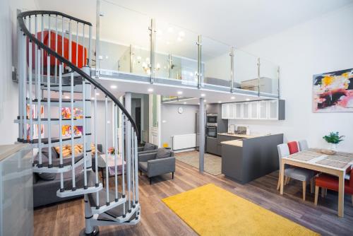 ein Wohnzimmer und eine Küche mit einer Wendeltreppe in einem Apartment in der Unterkunft Budapest Kálvin Apartman 2020 in Budapest