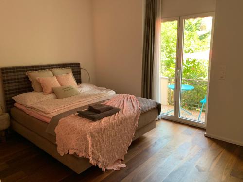 - une chambre avec un lit et une porte coulissante en verre dans l'établissement Brig City Garden Apartment, à Brigue